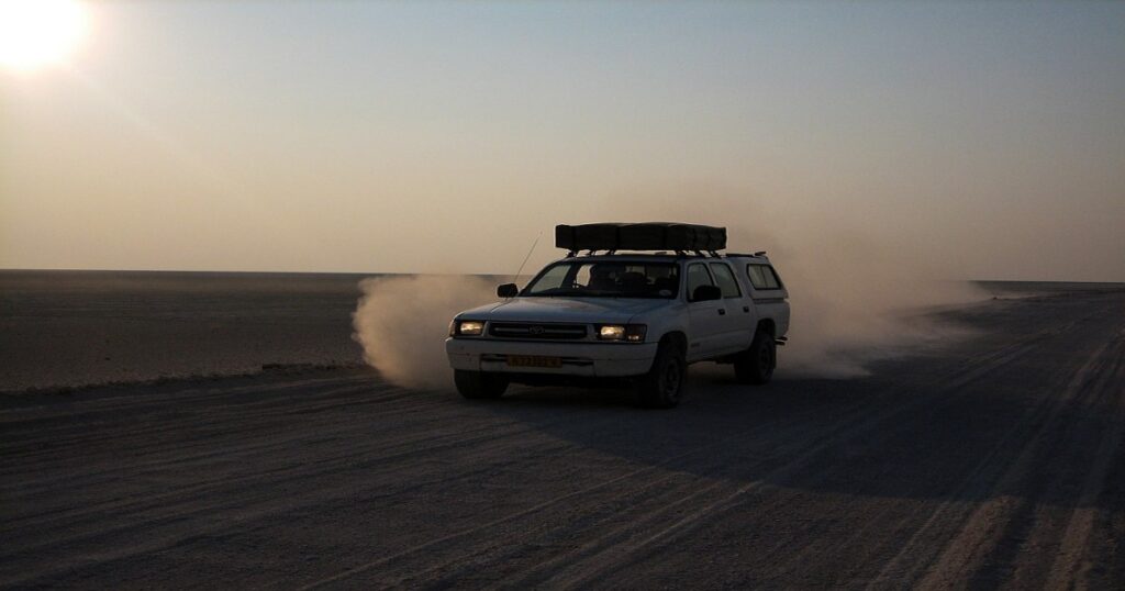 Truck driving on dusty road in the desert